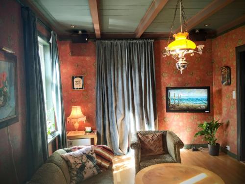 a living room with a table and chairs and a chandelier at Villa Villekulla in Kristiansand