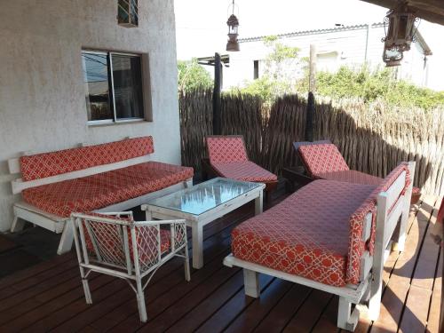 a group of chairs and tables on a deck at Excelente Casa Cumbre del Diablo 3 in Punta Del Diablo