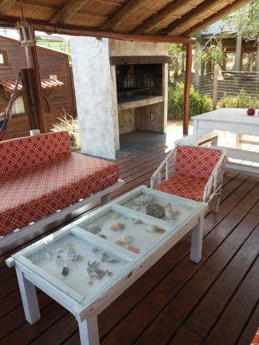 a patio with a table and chairs and a fireplace at Excelente Casa Cumbre del Diablo 3 in Punta Del Diablo