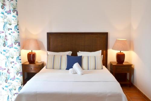 una camera da letto con un grande letto bianco con due lampade di M&L Beach House ad Alvor