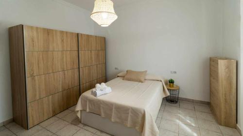 a bedroom with a bed and a large wooden cabinet at Casa Rural Silvia y Melissa in La Puebla de Cazalla