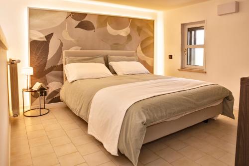 1 dormitorio con 1 cama grande y una pintura en la pared en Ypa Home Lago di Candia Canavese, en Candia Canavese