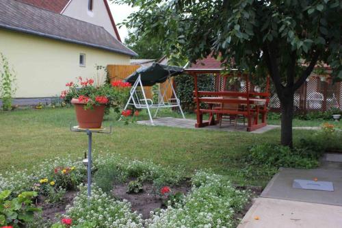 um jardim com uma mesa e um banco e flores em Balla Mama, Hajdúszoboszló em Hajdúszoboszló