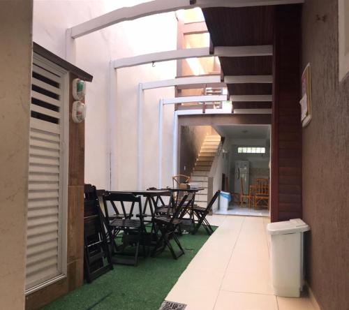 a hallway with tables and chairs in a building at Hospedagem Caravela in Arraial do Cabo