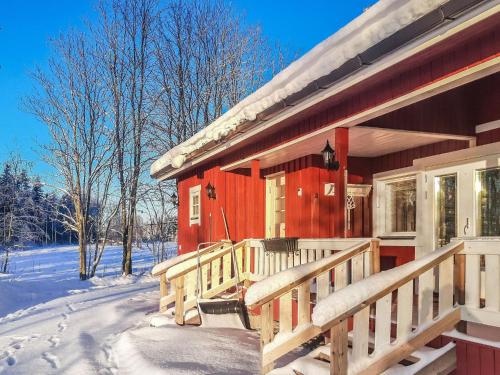 a red house with a porch in the snow at Holiday Home Juurlahti by Interhome in Hara