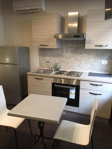 a kitchen with a table and a sink and a refrigerator at HH Hermoso Housing VALENZA in Valenza