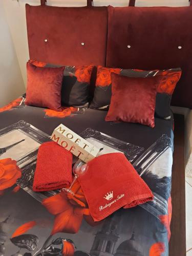 ein Bett mit roten Kissen und ein Buch darauf in der Unterkunft Buze Rodriguez Suite in Ostuni