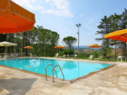 einen Pool mit Sonnenschirmen, Tischen und Stühlen in der Unterkunft Apartment Le Palaie - 'Piscina' - PEC205 by Interhome in Molino Mazzetti