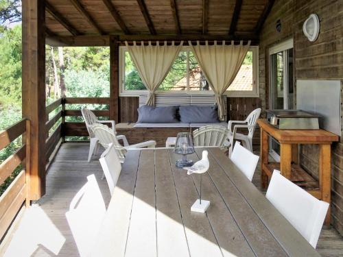 una mesa y sillas en la cubierta de una cabina en Chalet La Cigale - MAU190 by Interhome, en Carcans