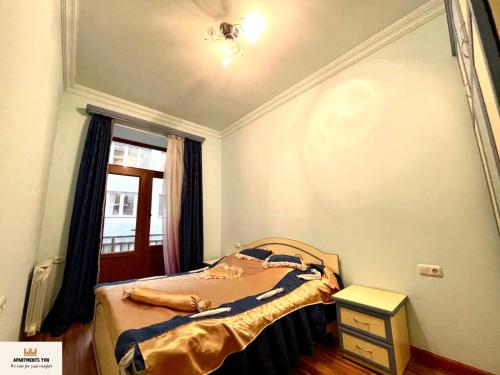 a small bedroom with a bed and a window at Armenak Apartment Near To Republic Square in Yerevan
