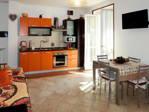 una cucina con armadi arancioni e tavolo con sedie di Apartment Samuele by Interhome a Civezza