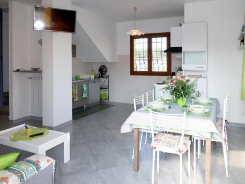 eine Küche und ein Esszimmer mit einem weißen Tisch und Stühlen in der Unterkunft Holiday Home Lavanda - AEG160 by Interhome in Albenga