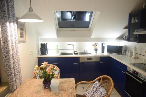 Una cocina con una mesa con un jarrón de flores encima. en Fewo Landweg, en Limburg an der Lahn
