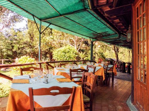 un restaurant avec des tables et des chaises et un toit verdoyant dans l'établissement Holiday Home Bungalow B - AEG401 by Interhome, à Villanova dʼAlbenga