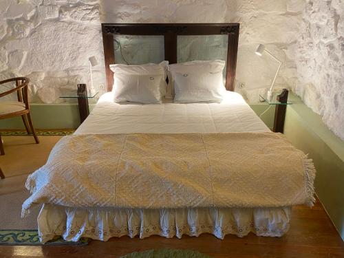 a bedroom with a large bed with white sheets and pillows at Quinta da Calçada in Melgaço