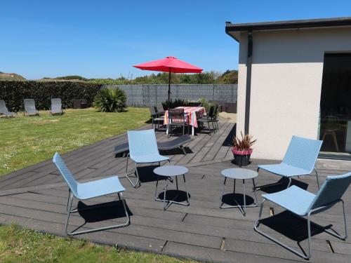 eine Terrasse mit Stühlen, einem Tisch und einem Sonnenschirm in der Unterkunft Holiday Home Ty Amiets - CED245 by Interhome in Cléder