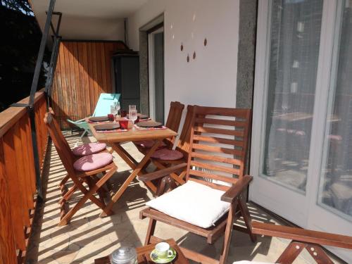 a porch with two chairs and a table on a balcony at Apartment Ginevra by Interhome in Sauze dʼOulx