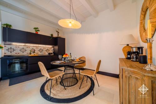 a kitchen with a table and chairs in a room at Casa Ramal - Tipica dimora Siciliana in Siracusa