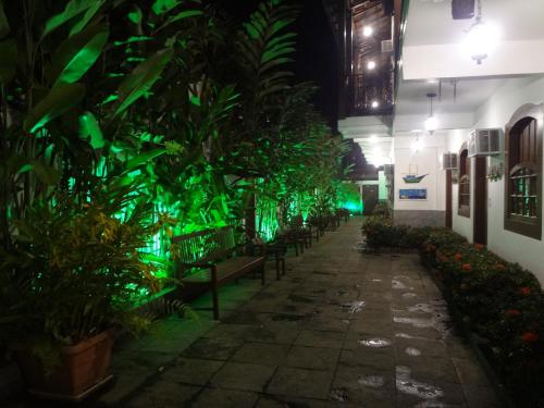 a hallway with plants and benches at night at Pousada Doce Paraty in Paraty