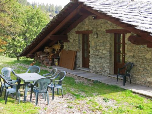 uma mesa e cadeiras em frente a uma casa de pedra em Chalet Casot Pra La Funt - SMY102 by Interhome em Sampeire