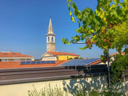 un campanario de la iglesia con una torre de reloj en el fondo en Apartment Attico di Marisa by Interhome, en Codroipo