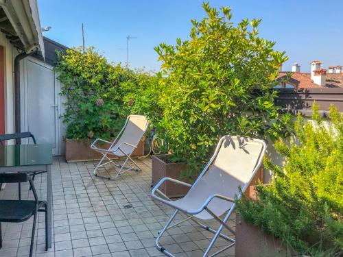 2 sillas sentadas en un patio con plantas en Apartment Attico di Marisa by Interhome, en Codroipo