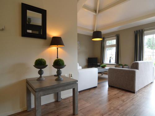 a living room with a table and a couch at Holiday home in the Veluwe in nature in Putten