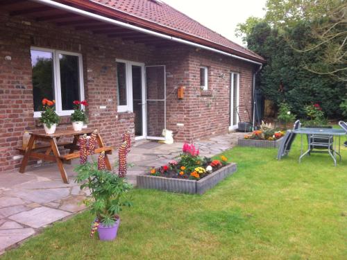 a patio with a table and flowers in the yard at Dreamy Holiday Home in Sweikhuizen in Spaubeek