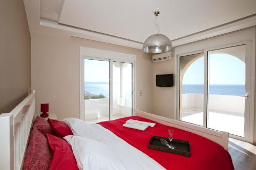 キオタリにあるKiotari Beach Villas - Luxury Retreatのベッドルーム1室(赤毛布付きの大型ベッド1台付)