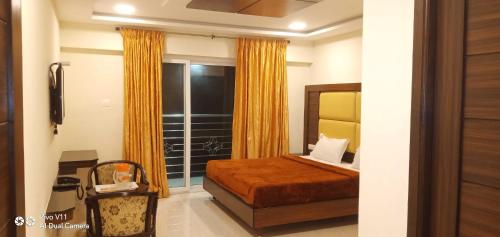 a bedroom with a bed and a large window at B2B Home Stay in Kodaikānāl
