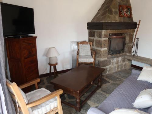 sala de estar con chimenea, mesa y sofá en Holiday Home Les Confoulines by Interhome, en Usclades