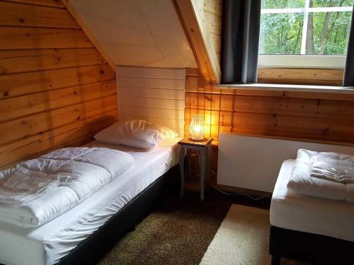 フンデルローにあるGround-floor Bungalow in Borgerende-Rethwisch with Saunaの木造キャビン内のベッド2台が備わる部屋