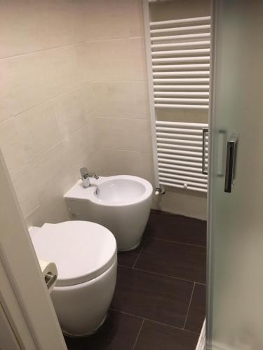 a bathroom with a white toilet and a sink at HH Hermoso Housing VALENZA in Valenza