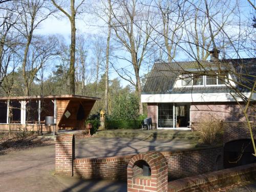 a brick house with a brick wall in front of it at Holiday home with pool sauna in Lunteren