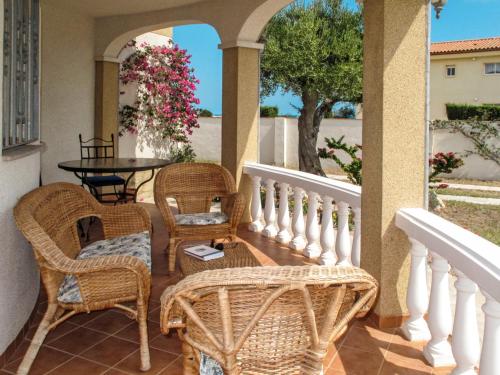 porche con sillas de mimbre, mesa y mesa en Holiday Home Silvia - MPL231 by Interhome en Miami Platja