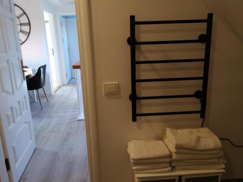 een handdoekenrek naast een gang met een kamer bij Apartamentai Ramybė in Nida