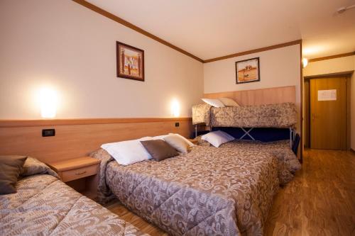 a hotel room with two beds in a room at Hotel Vittoria in Folgaria