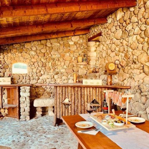 kamienna kuchnia ze stołem i kamienną ścianą w obiekcie Tenuta Blancamar Country Bed & Breakfast w mieście Crisionis
