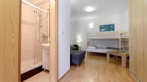 a small bathroom with a shower and a bed and a sink at Sunset Apartments in Crikvenica