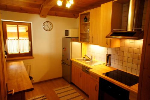 a kitchen with a refrigerator and a sink and a clock at Apartments Seegartl in Fuschl am See