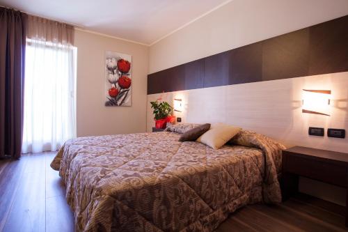 a bedroom with a large bed in a room at Hotel Vittoria in Folgaria