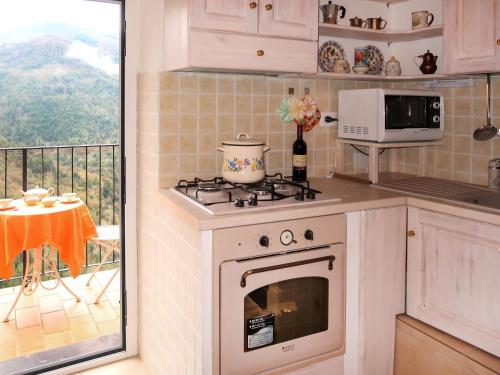 una cucina con piano cottura forno superiore accanto a un balcone di Holiday Home Reanna by Interhome ad Apricale