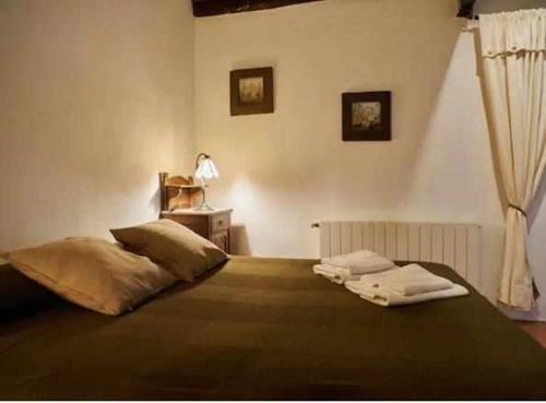 a bedroom with a bed with two towels on it at Masia Olivera in Sant Pau dʼOrdal