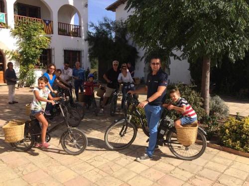 a man and two children sitting in baskets on bikes at Masia Olivera in Sant Pau dʼOrdal
