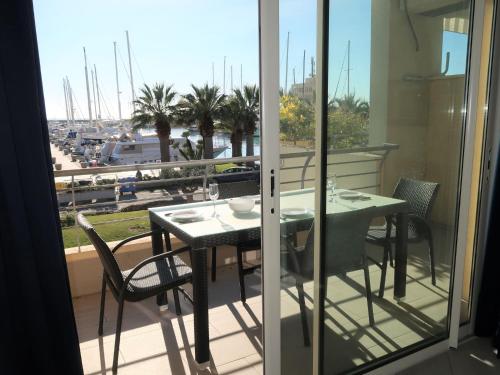 a table and chairs on a balcony with a view of a harbor at Apartment Marta by Interhome in Terzorio