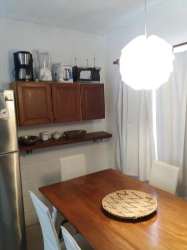 a kitchen with a wooden table and a refrigerator at Excelente Casa Cumbre del Diablo 3 in Punta Del Diablo