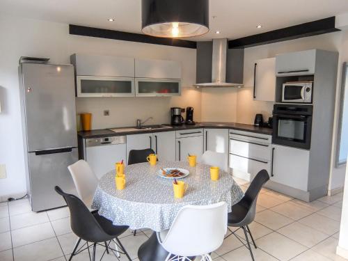 une cuisine avec une table et des chaises dans une cuisine dans l'établissement Holiday Home Villa de la Mer by Interhome, à Saint Cyprien Plage