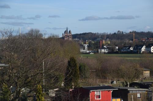 una ciudad con una casa roja y un castillo en el fondo en Fewo Landweg, en Limburg an der Lahn