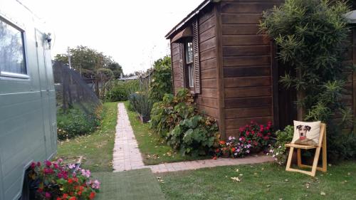 einen Garten mit einem Stuhl und Blumen neben einem Gebäude in der Unterkunft The Whare Rural Retreat in Hastings