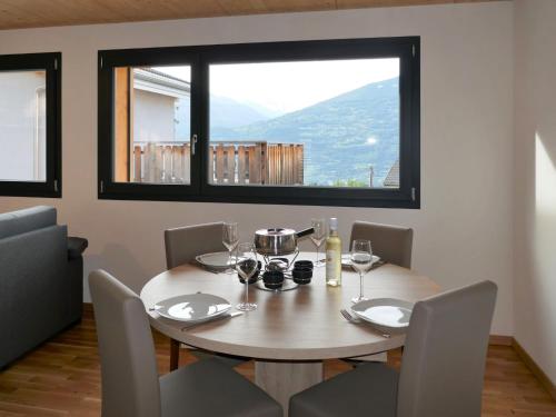 a dining room with a table and chairs and a window at Chalet Le Raccard by Interhome in Savièse